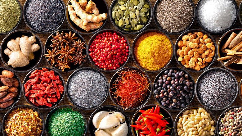 Colourful background from various herbs and spices for cooking in bowls. Top view